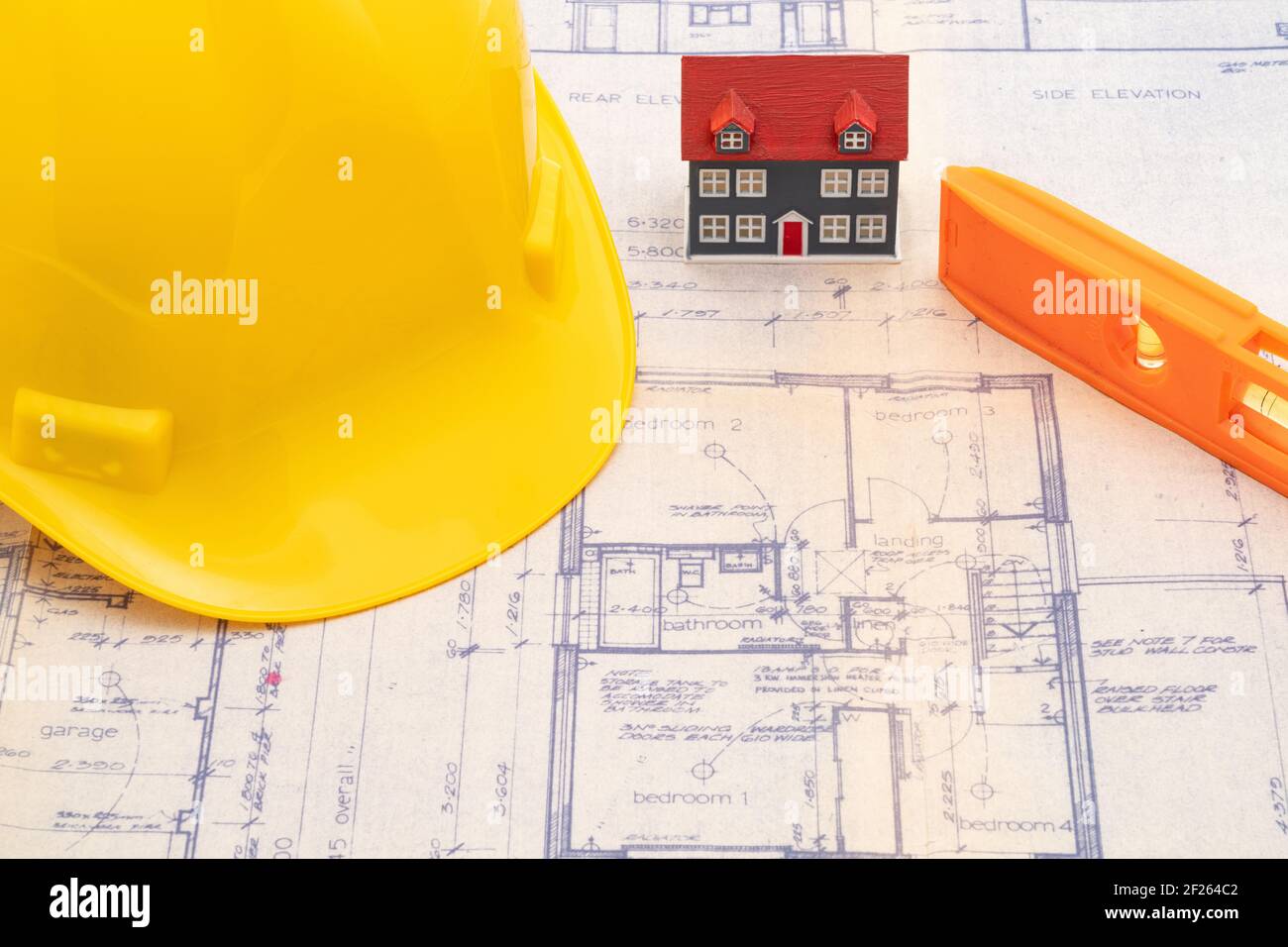 Progetti di costruzione della casa con un elmetto giallo e piccolo casa modello Foto Stock