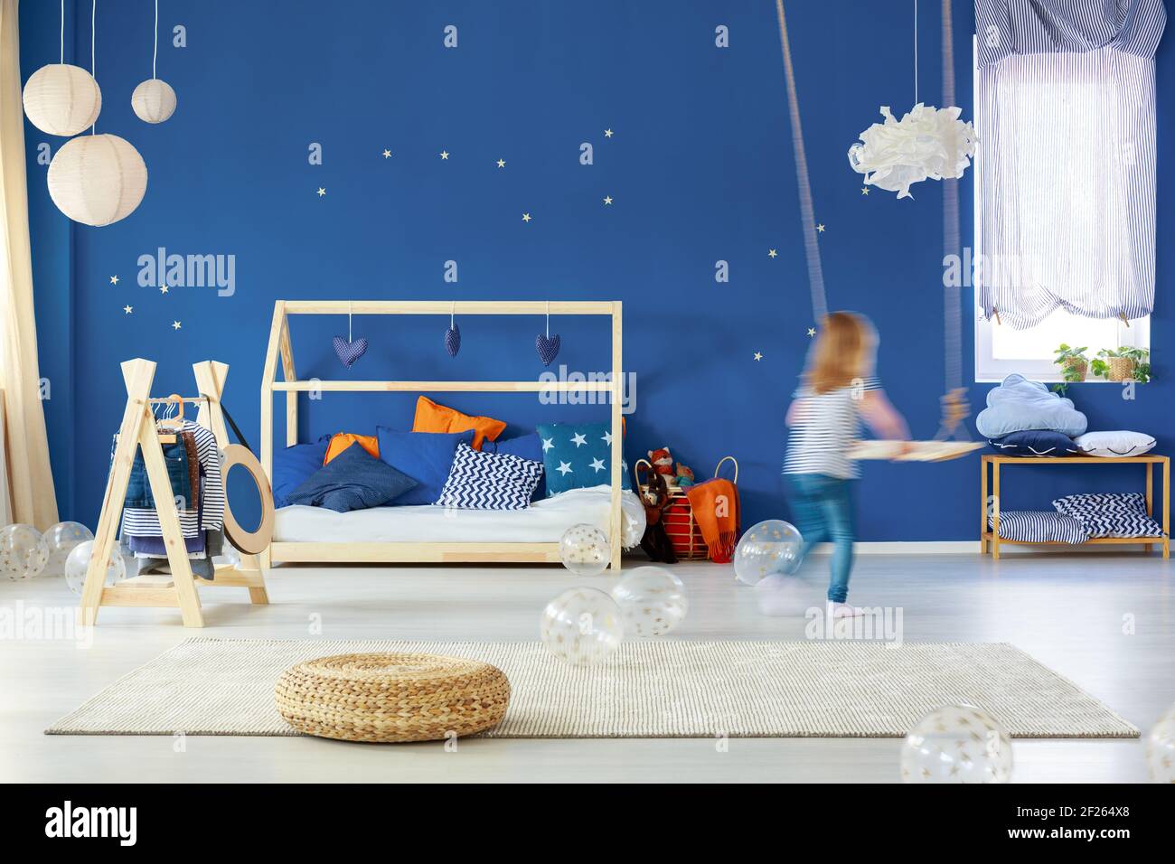 Blue camera per bambino con altalena, letto in legno, lampade, rattan pouf Foto Stock