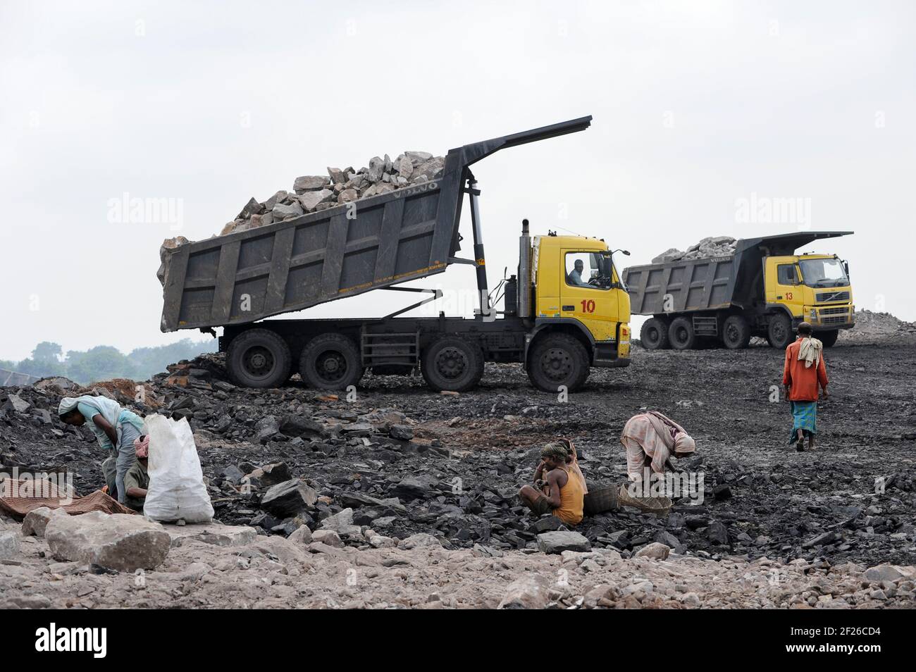 INDIA, Jharkhand, Dhanbad Jharia, BCCL carbone miniera sito, Volvo camion scarico sovraccarico, carbone picker, persone raccogliere illegalmente carbone da coalfield per vendere sul mercato per la sussistenza / INDIEN, Dhanbad Jharia, BCCL Kohletagebau, Volvo Kipper carico Abraum ab, mensmeln Kohle Markau Verkauf Foto Stock