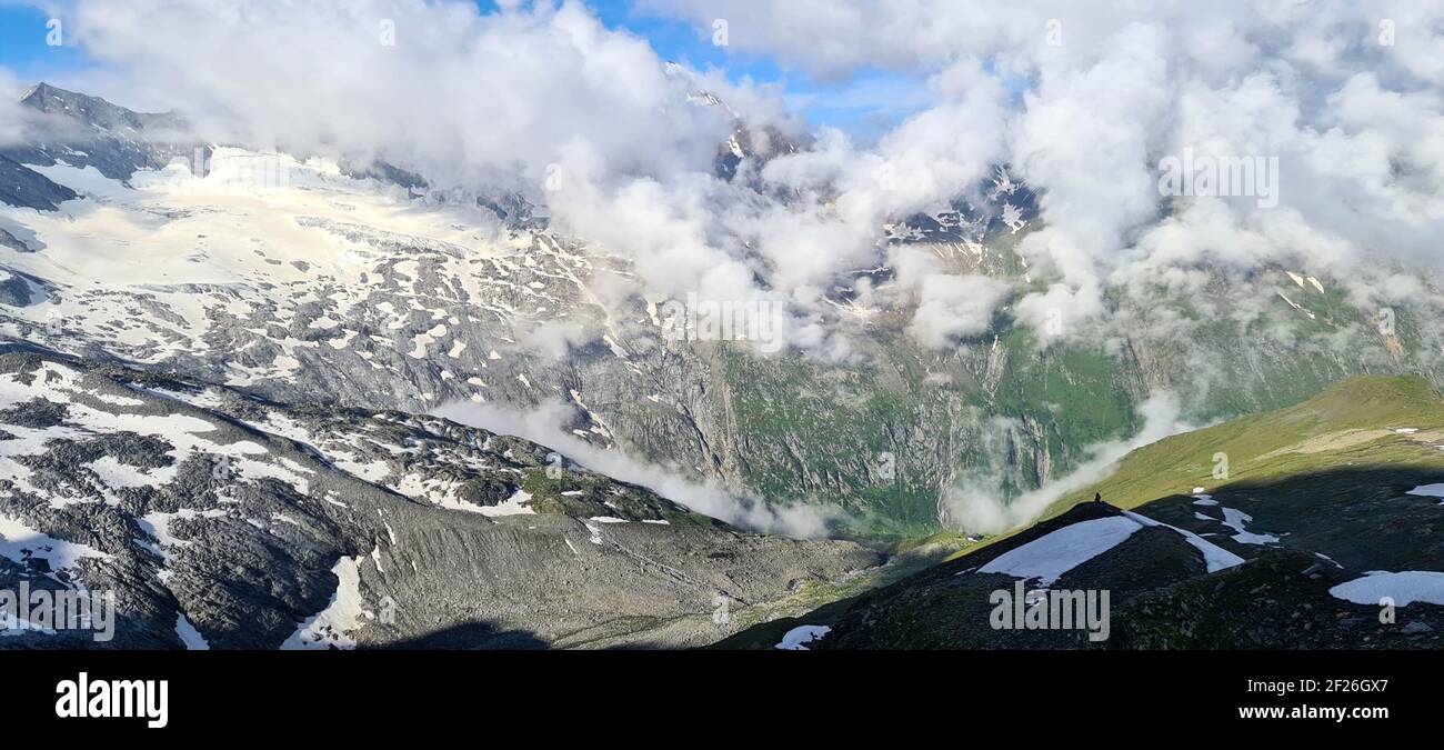 Paesaggio innevato con montagne e nuvole che creano una magia Atmosfera mattutina nelle Alpi Zillertal in Austria Foto Stock