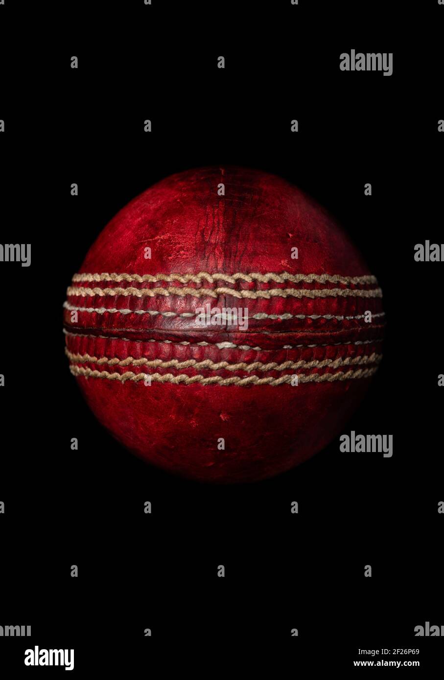 Palla di cricket in pelle rossa su sfondo nero Foto Stock