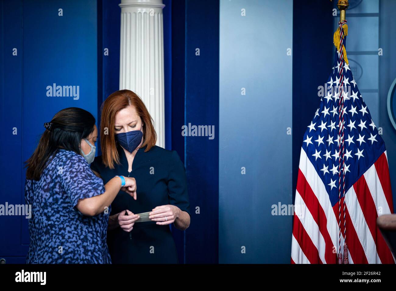 Jen Psaki, segretario stampa della Casa Bianca, indossa una maschera protettiva mentre riceve una nota da Angela Perez, assistente stampa della Casa Bianca, durante una conferenza stampa nella stanza di Briefing della Stampa di James S. Brady presso la Casa Bianca a Washington, DC, Stati Uniti, mercoledì 10 marzo, 2021. Psaki ha detto ieri che il governo non avrà i controlli di stimolo di soccorso Covid-19 stampati con il nome del presidente Biden su di loro, come il Tesoro cerca di accelerare la loro distribuzione. Credito: Al Drago/Pool via CNP /MediaPunch Foto Stock