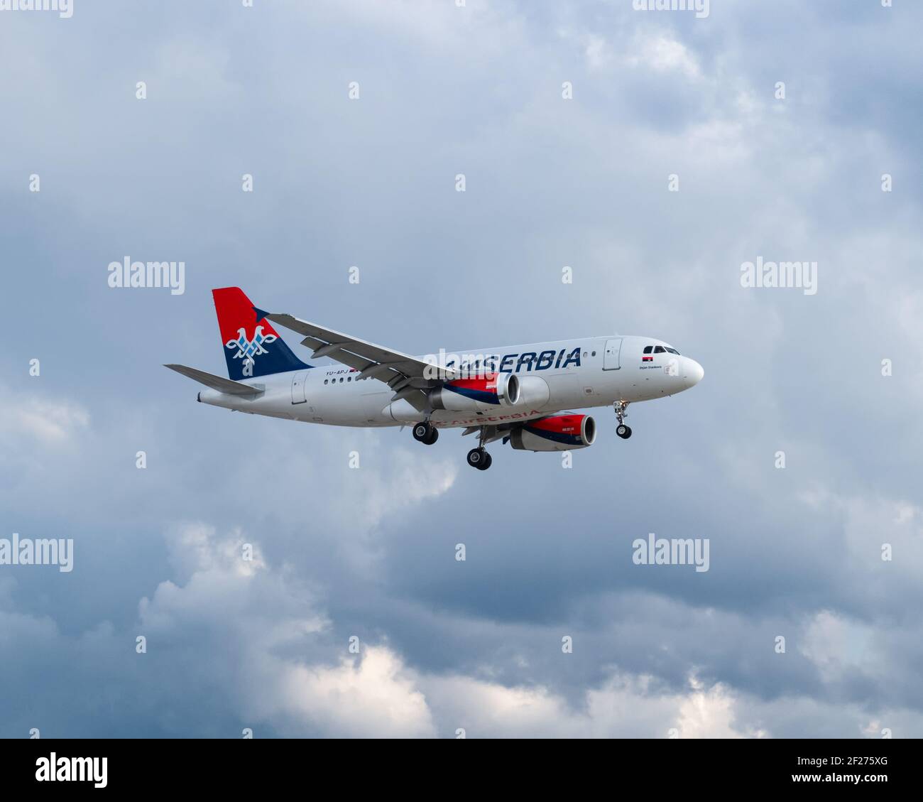 Londra, Aeroporto di Heathrow - Maggio 2019: Air Serbia, Airbus A319 che vola attraverso un cielo nuvoloso grigio all'avvicinamento finale con il suo approdo giù. Immagine Abd Foto Stock