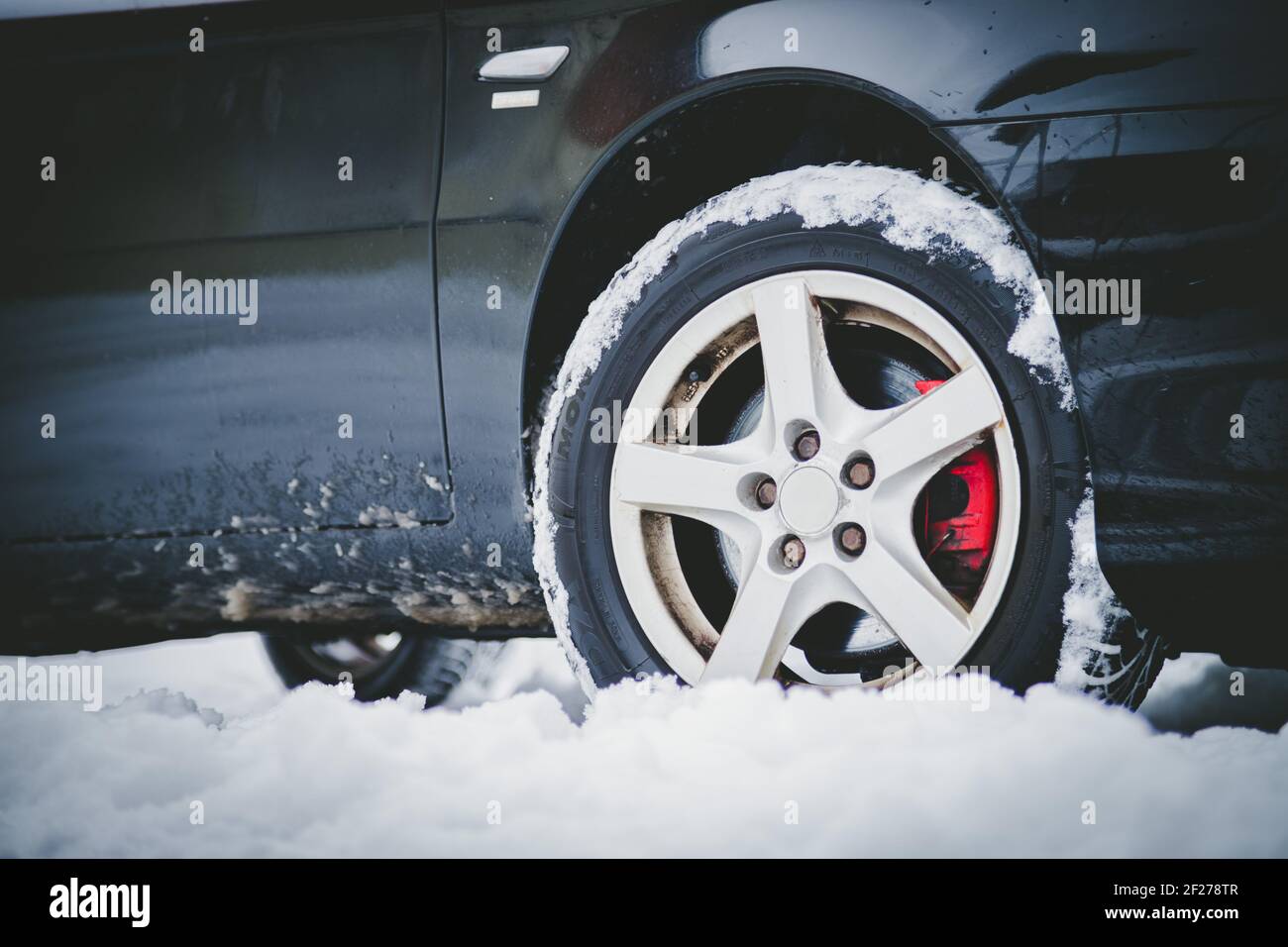 Pneumatico auto in inverno sulla strada coperta di neve, primo piano immagine Foto Stock
