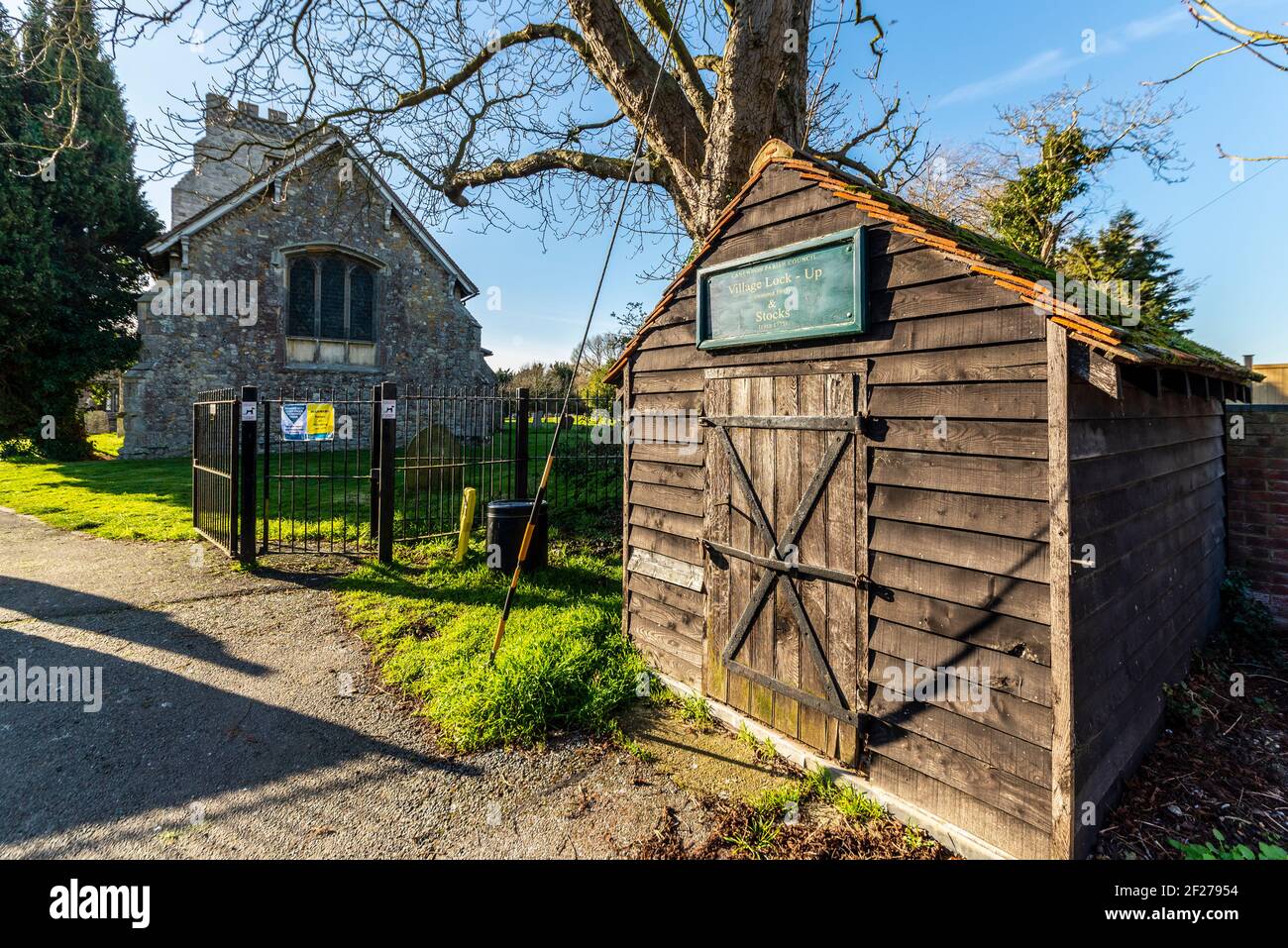 Blocco in legno e costruzione di stock dalla chiesa parrocchiale di San Nicola a Canewdon, Essex, Regno Unito. Carcere temporaneo per criminali Foto Stock