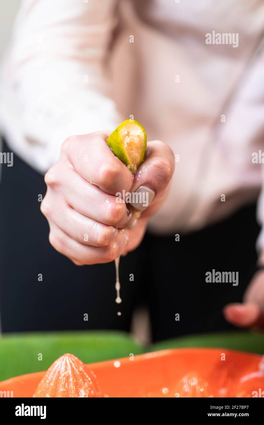 chef stringendo il lime con la mano Foto Stock