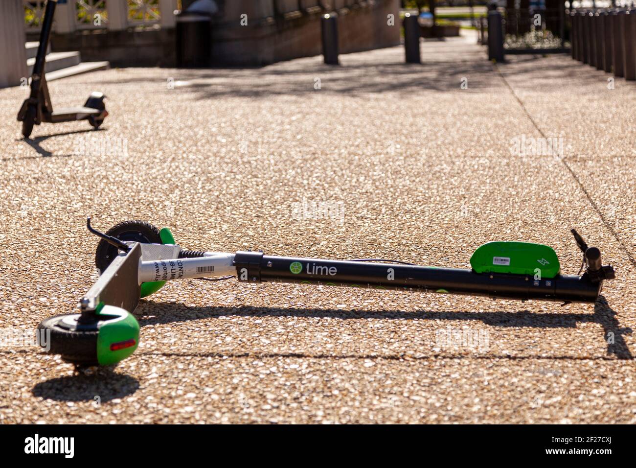 Washington D.C. , USA 11-02-2020: Uno scooter elettrico appartenente alla rete di noleggio di scooter Lime è abbandonato sulla passeggiata laterale a Washington DC. Il Foto Stock