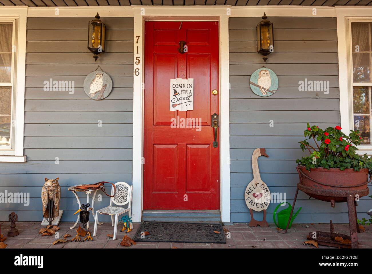 Clifton, VA, USA, 11-14-2020: Ingresso di una casa di epoca coloniale nella città storica. La porta rossa ha un segno che dice di entrare per un incantesimo con un simbolo di strega su Foto Stock