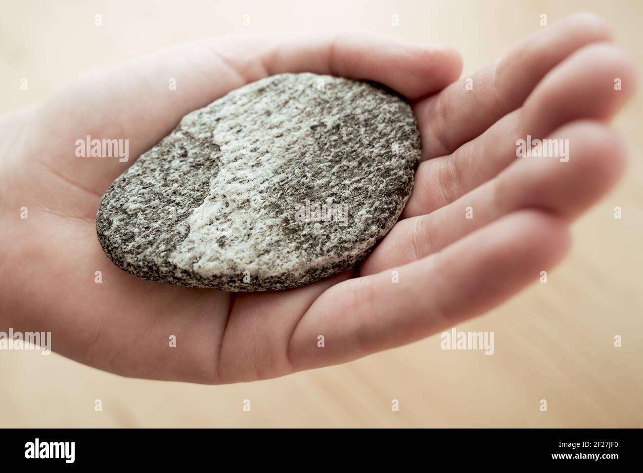 Donna che tiene la pietra luminosa con le forme d'onda come un simbolo di equilibrio per la meditazione Foto Stock