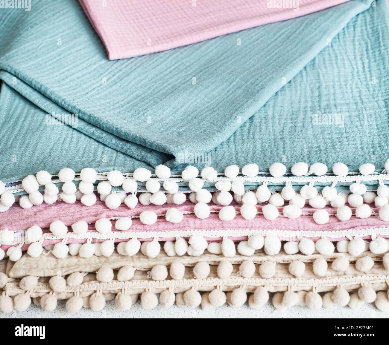 Sfondo da coperte di mussola con pom-pom. Tessuti per la casa in cotone  biologico. Asciugamani e lenzuola in mussola Foto stock - Alamy