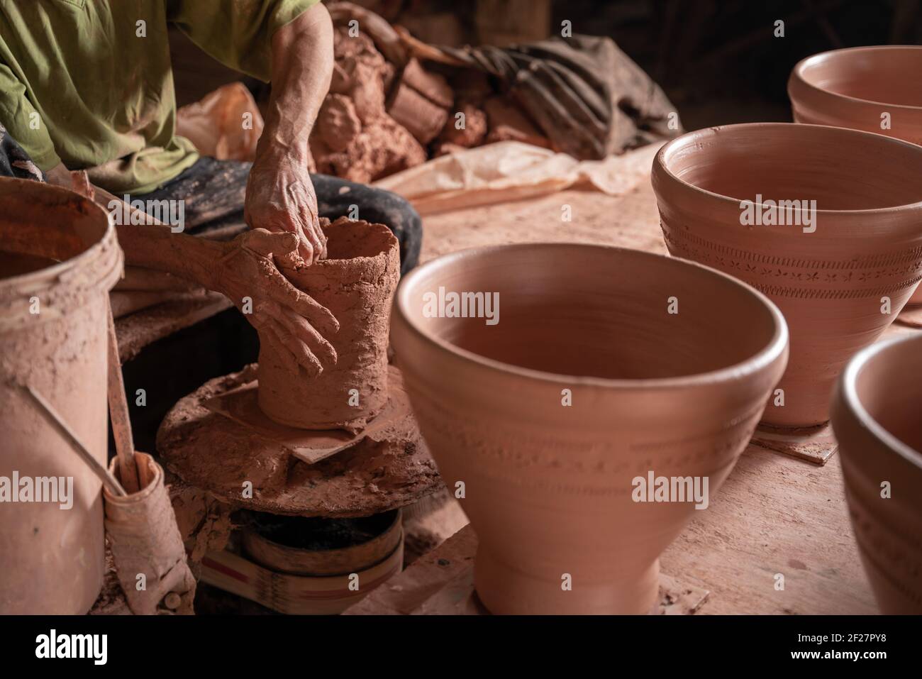 Primo piano mano di uomini che lavorano sulla ruota del vasaio. Mani sculpta un mortaio da creta pot. Creta ware fatto a mano sulla ruota del vasaio in thailandia. Foto Stock