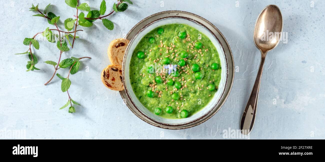 Panorama zuppa vegana, crema verde con toast e menta fresca Foto Stock
