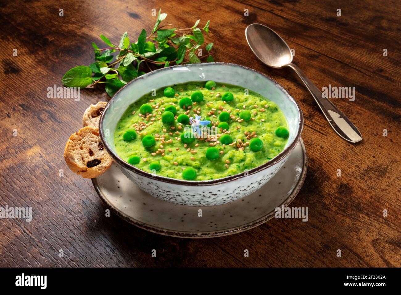 Zuppa vegana con menta e piselli verdi, con pane tostato Foto Stock
