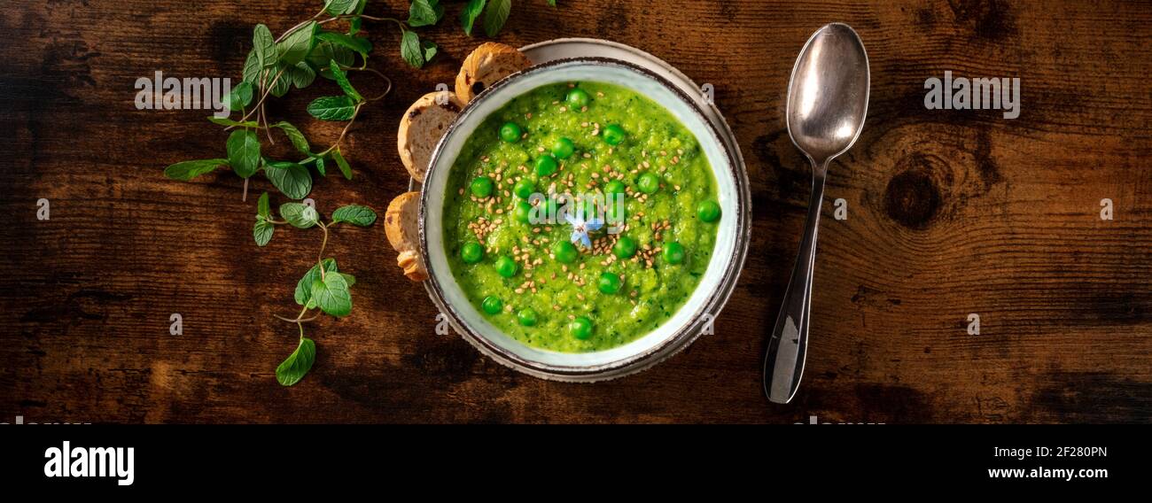 Panorama pasto vegano, zuppa di crema verde con toast e menta fresca Foto Stock