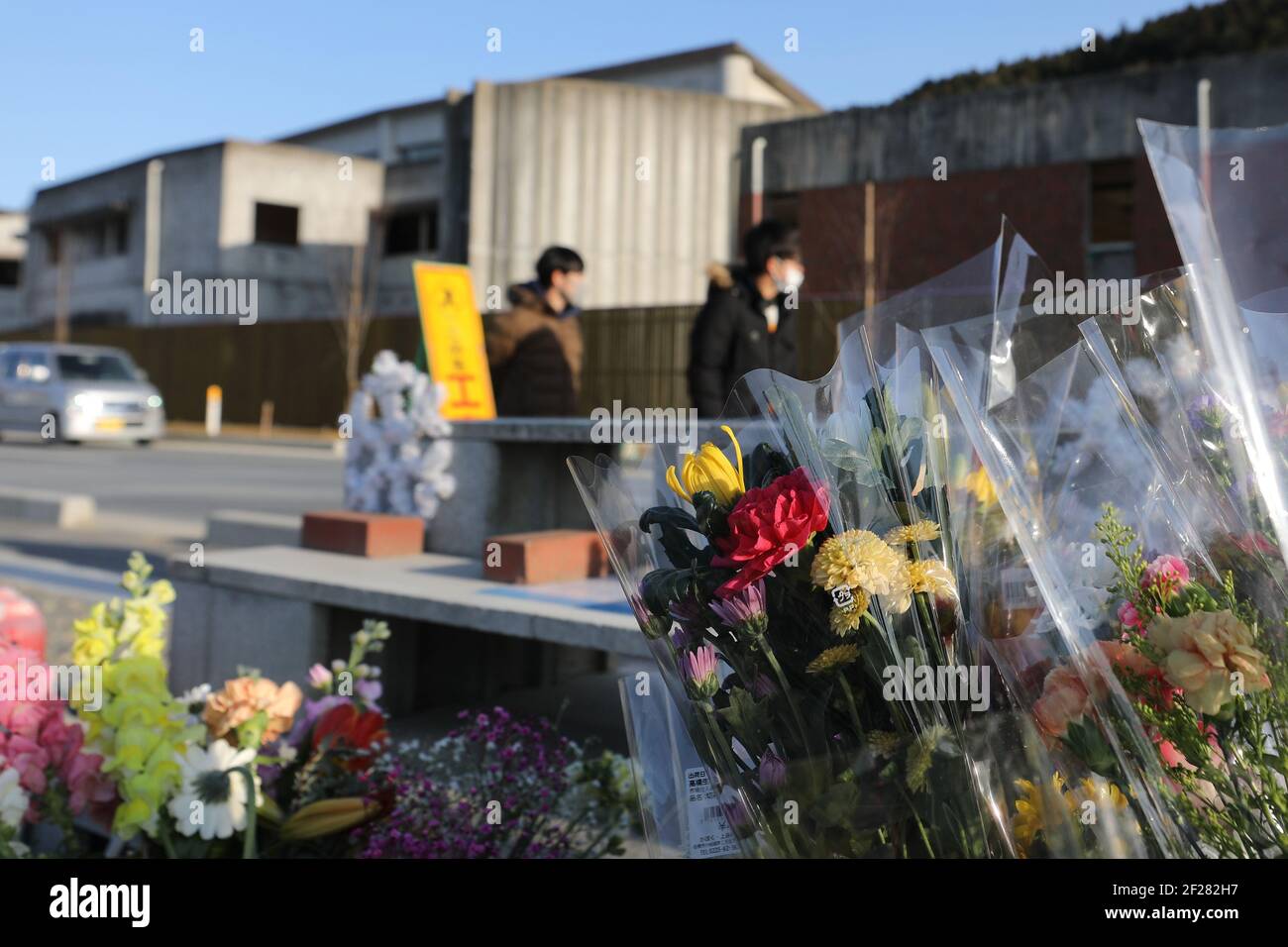 Ishinomaki, Giappone. 9 marzo 2021. I fiori sono posati davanti alle rovine della scuola elementare Okawa a Ishinomaki, Giappone, 9 marzo 2021. Una scuola elementare pubblica nella prefettura di Miyagi ha perso più di 80 vite nello tsunami a seguito del terremoto del 2011 marzo nel Giappone nordorientale. Dieci anni dopo, le rovine dell'edificio scolastico raccontano ancora l'inimmaginabile tragedia della calamità. PER ANDARE CON 'Feature: 10 anni dopo, la scuola giapponese di tsunami-colpito ancora dice tragedia inimmaginabile' Credit: Du Xiaoyi/Xinhua/Alamy Live News Foto Stock