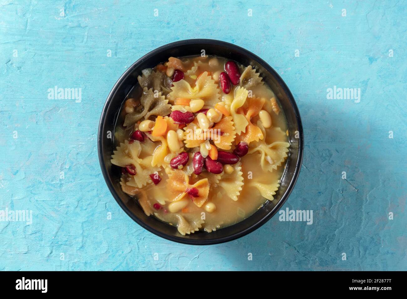 Zuppa vegana con pasta e fagioli, sparata dall'alto Foto Stock