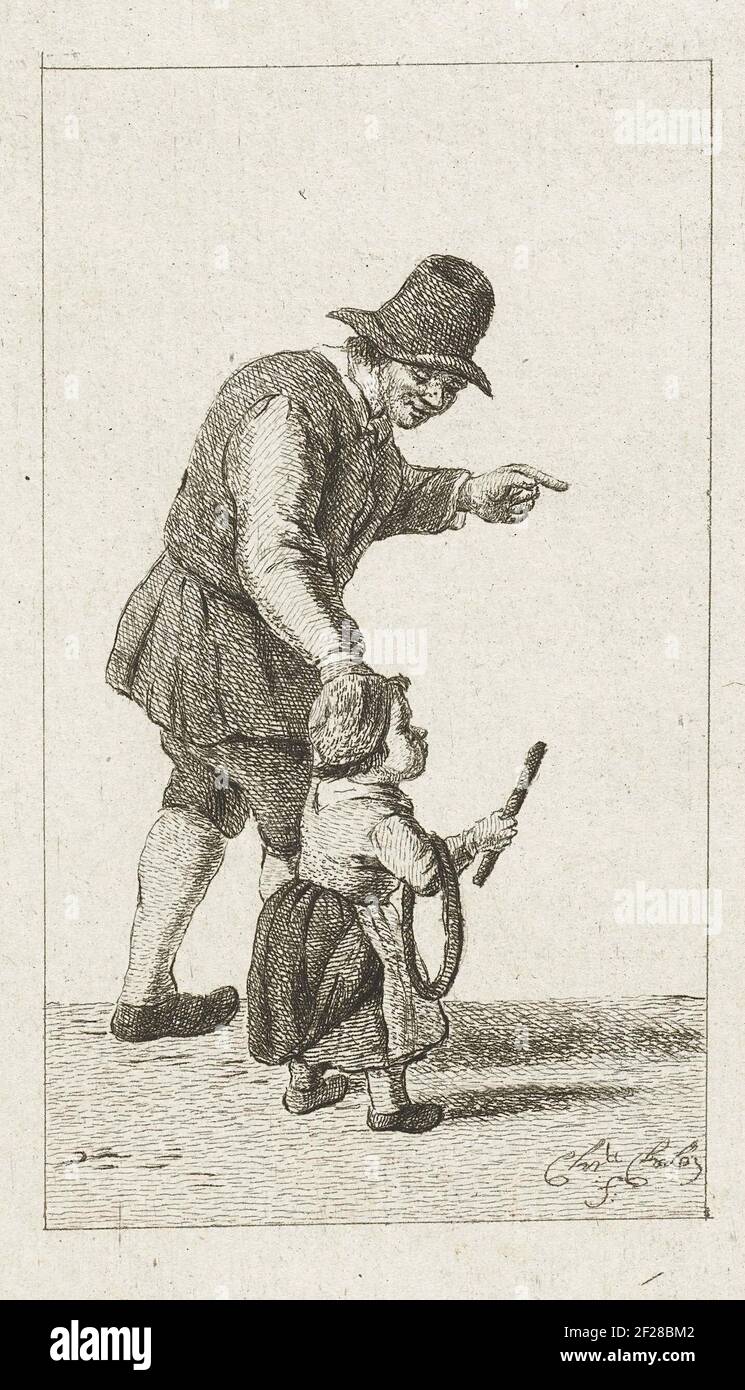 L'uomo di Staande ha incontrato genere hoepel.A padre gioca con suo figlio. Ha il bambino a portata di mano. Il figlio ha un cerchio e un bastone con cui può estrarre il cerchio. Foto Stock