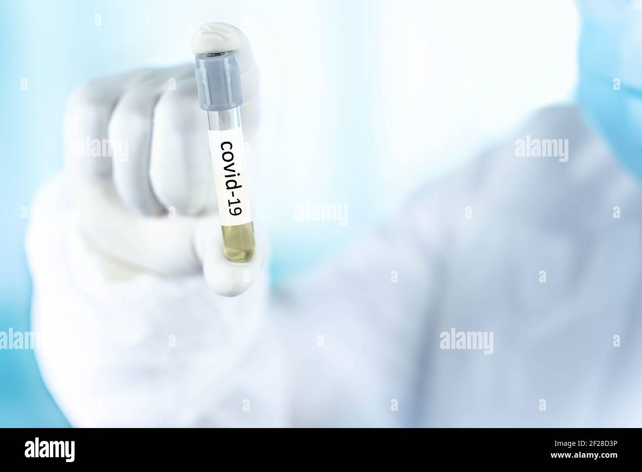 Primo piano una provetta in mano a un medico del laboratorio scientifico, un concetto di consumo di droga per trattare e proteggere la pandemia globale COVID-19. Foto Stock