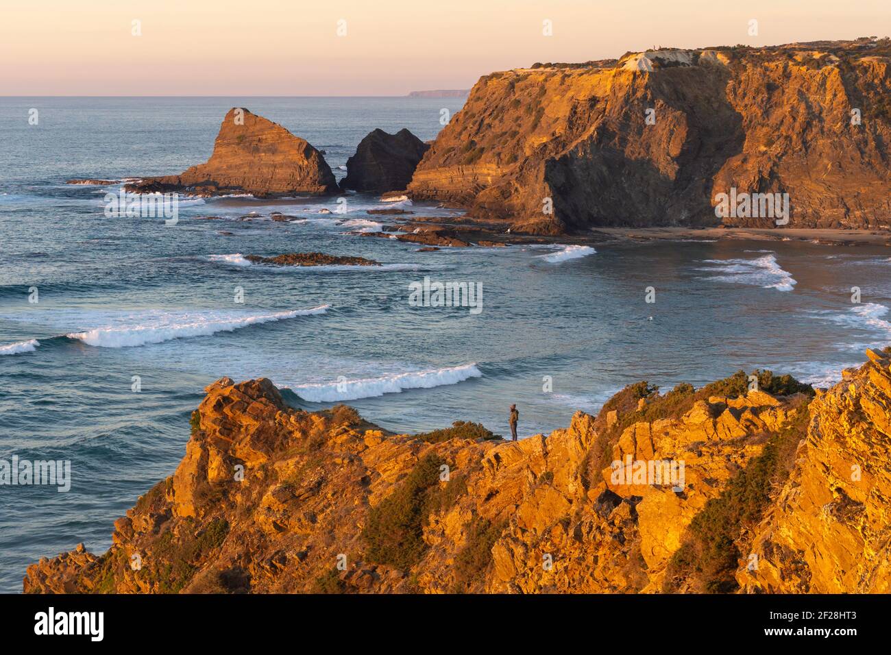 Donna su una scogliera a Praia de Odeveixe in Costa Vicentina, Portogallo Foto Stock