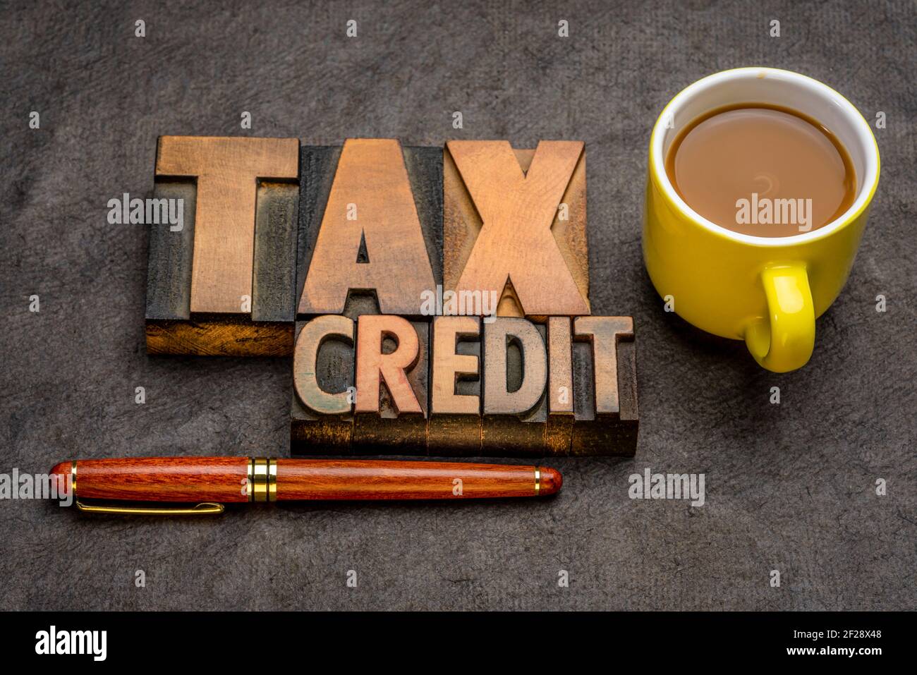 banner di credito fiscale - abstract di parole in vintage letterpress stampa blocchi contro carta testurizzata con una tazza di caffè, business concetto finanziario Foto Stock