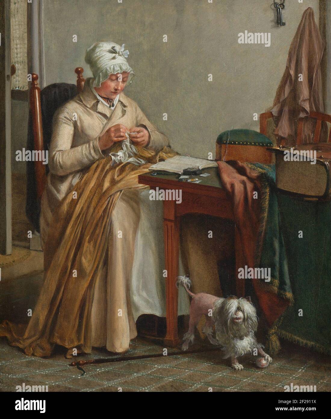 Interni con Donna cucire.‘il diavolo trova lavoro per le mani inutilizzate’ è l’essenza dell’etica olandese della pietà e del duro lavoro. Come incarnato in questa scena: Un interno sobrio con una donna che cucina un orlo e contemporaneamente legge un libro. Un volume denso della traduzione olandese autorizzata della Bibbia giace su una tovaglia ripiegata, pronta per essere aperta. Nel frattempo, un cane con una palla di lana sta per infrangere la concentrazione silenziosa. Foto Stock