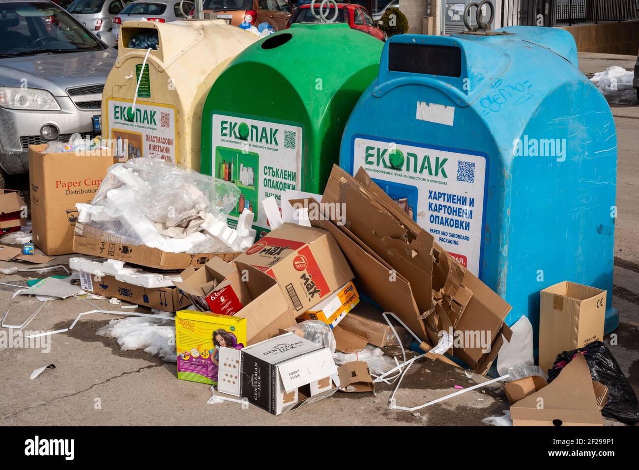 Rifiuti intorno a contenitori di riciclaggio misti. Cartoncini scaricati accanto ai contenitori di riciclaggio completi. Punto di raccolta rifiuti rifiuti a Sofia Bulgaria, Europa, UE Foto Stock