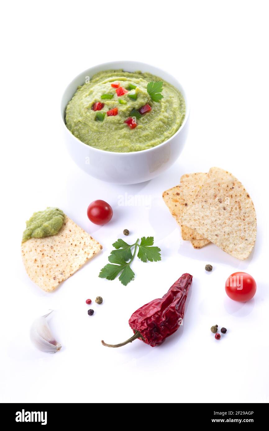 Ciotola di guacamole e nachos isolati su sfondo bianco. Formato verticale. Foto Stock