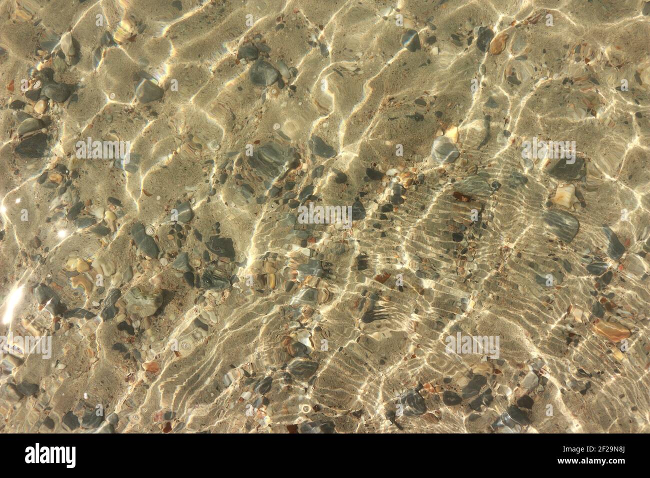 La superficie dell'acqua è così chiara che si può vedere attraverso e vedere le rocce sotto. Foto Stock
