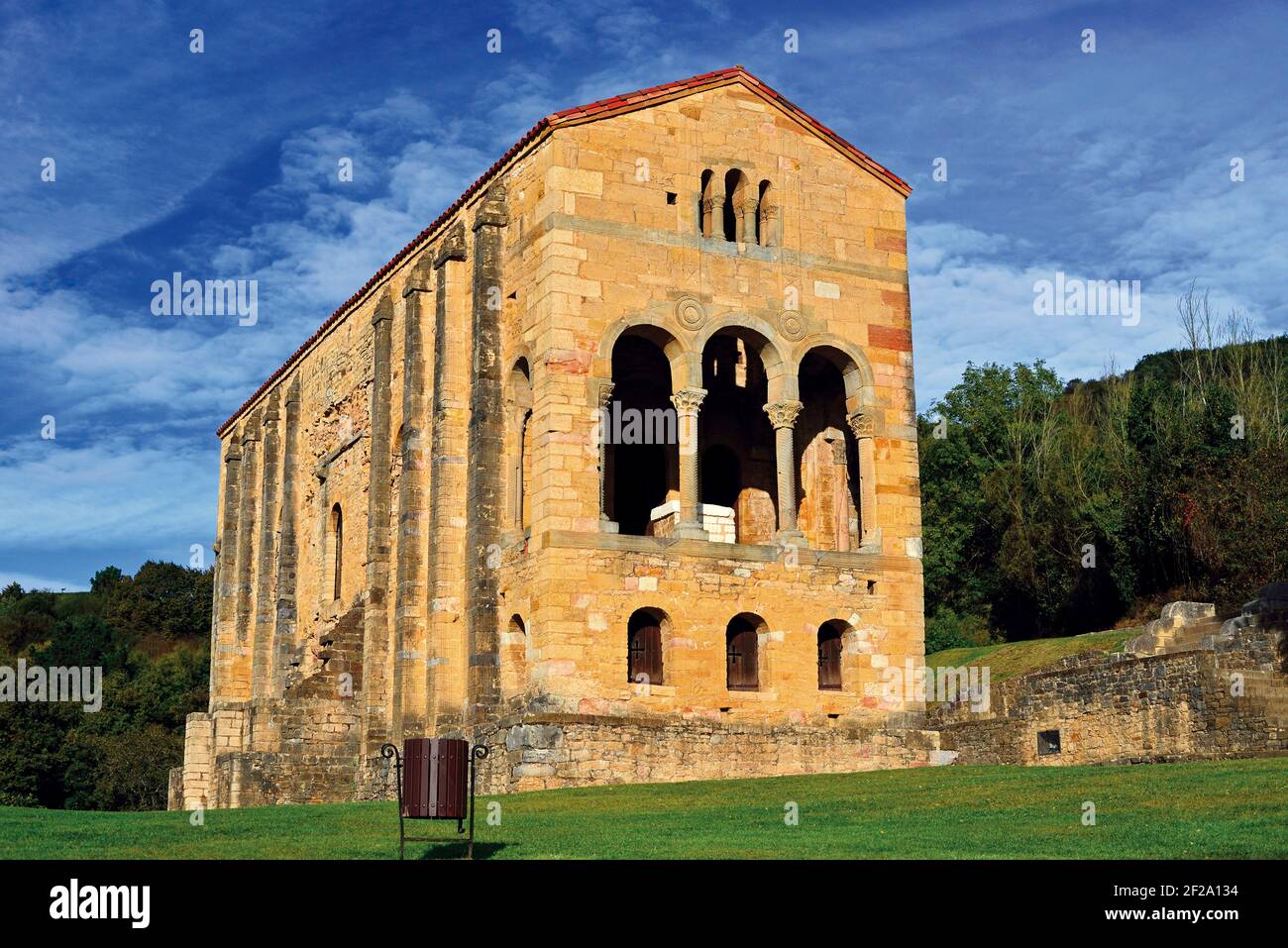 Tempio pre-romanico da solo circondato da verdi colline e campi di erba (Santa Maria del Naranco, Oviedo) Foto Stock