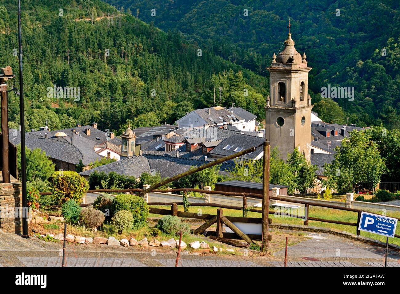 Panoramica del piccolo villaggio di montagna con la torre centrale della chiesa circondata da foreste verdi Foto Stock