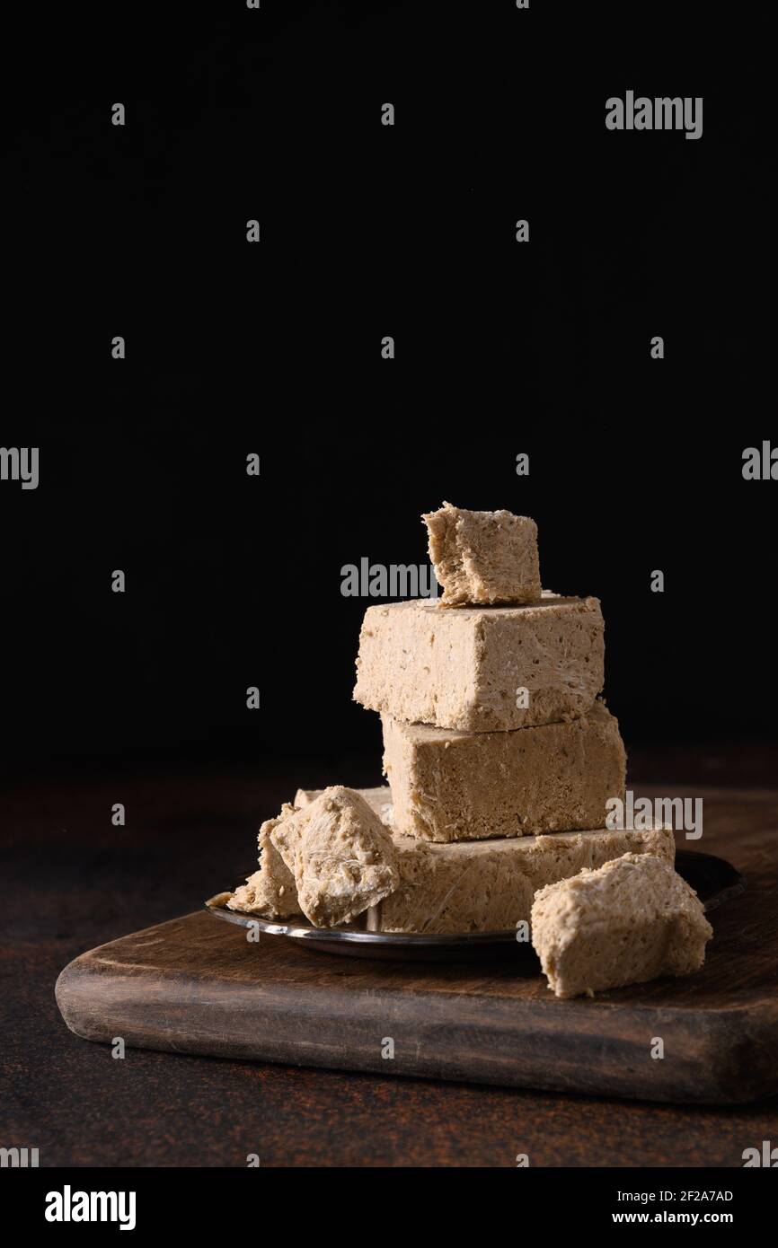 Gustosa halva dolce orientale preparato da semi di girasole su sfondo scuro. Verticale orientale. Primo piano. Foto Stock