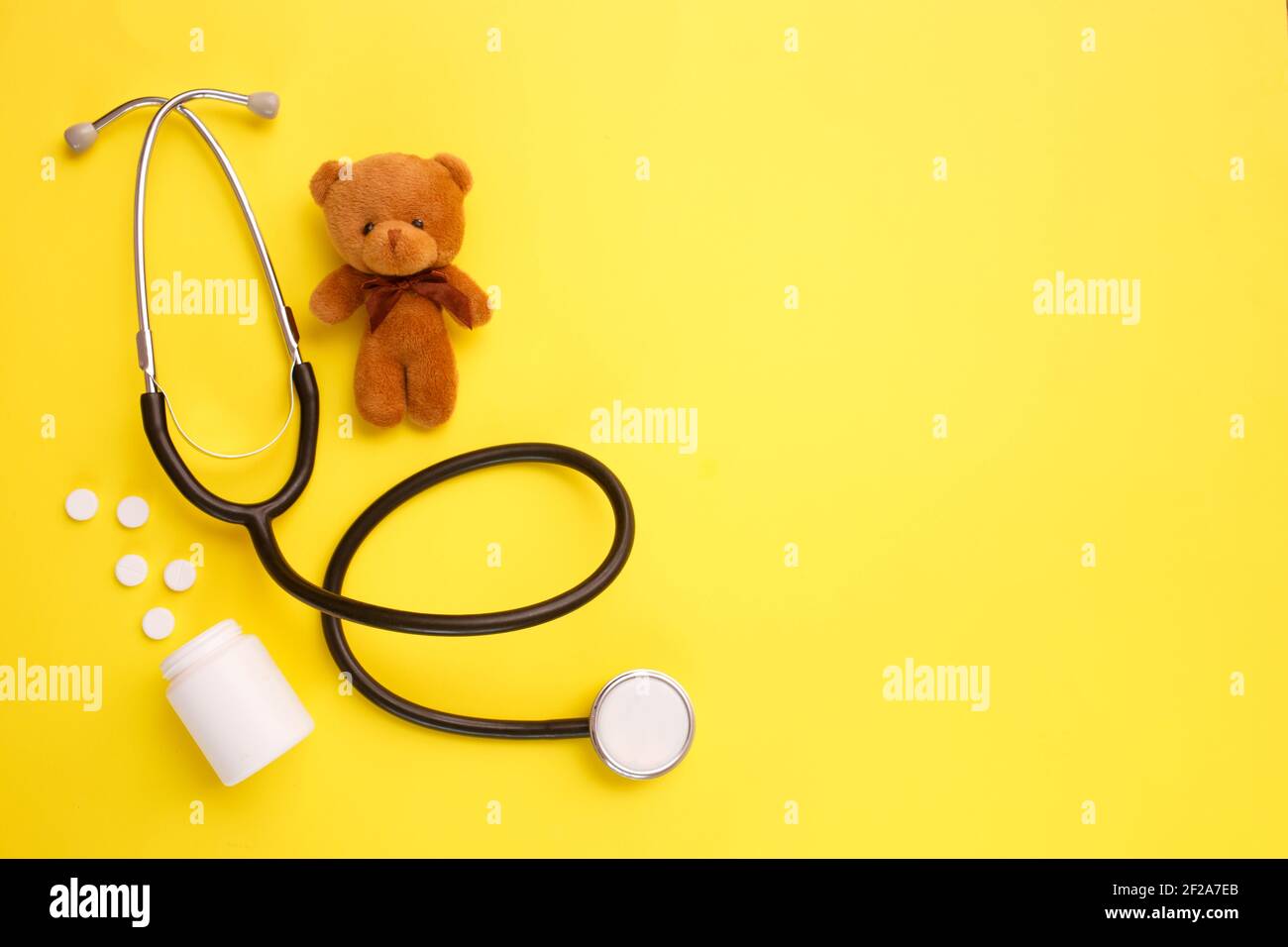 Orsacchiotto giocattolo per bambini con stetoscopio su sfondo giallo con  spazio per la copia. Concetto di salute dei bambini. Vista dall'alto,  disposizione piatta Foto stock - Alamy