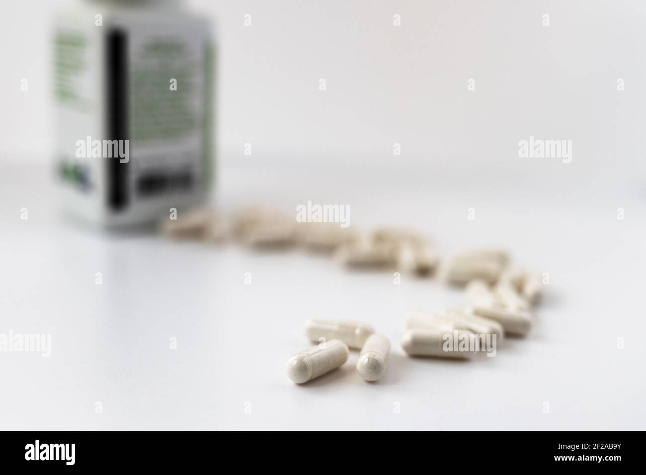 foto a fuoco selettivo delle capsule di orotato di litio, versata dal vaso. concetto dietetico. supplemento dietetico foto a profondità di campo limitata Foto Stock