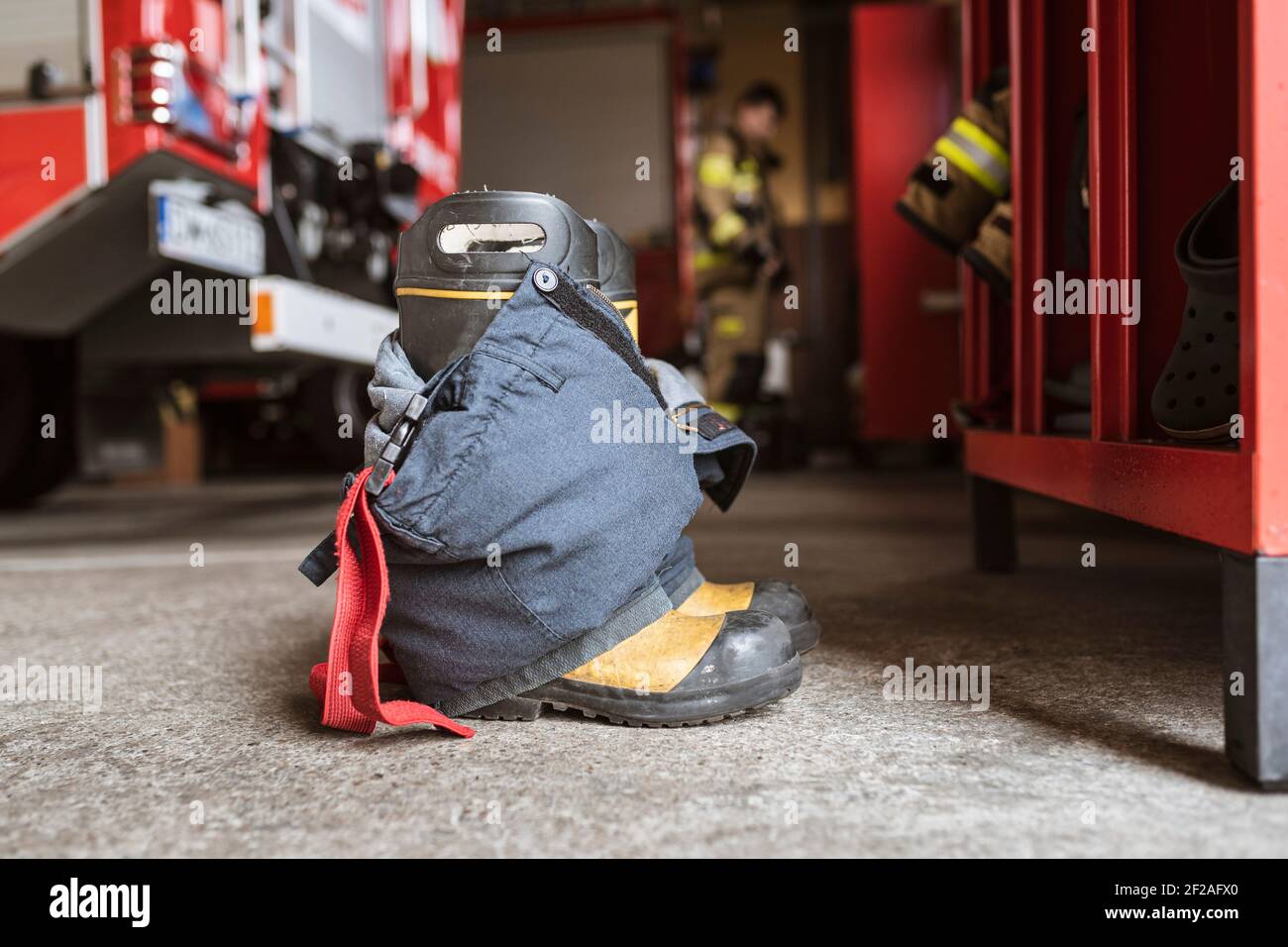 Scarpe e pantaloni per vigili del fuoco e armadio, camion e pompieri sullo  sfondo Foto stock - Alamy