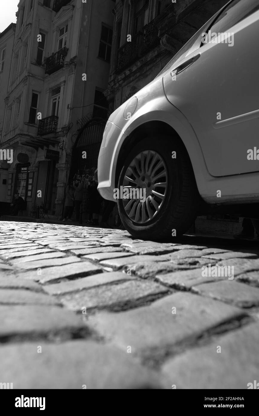 Un'immagine in scala di grigi di una moderna auto sportiva sul strada asfaltata in una giornata di sole Foto Stock