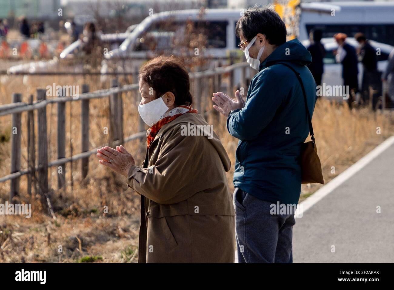 Ishinomaki, Giappone. 11 Marzo 2021. Una preghiera silenziosa è detta durante 14:46 il tempo del terremoto in 2011. Le famiglie e gli amici vengono a cercare nomi e offrono fiori e pagatori in ricordo dei cari nel nuovo parco commemorativo inaugurato oggi a Ishinomaki. Il Giappone segna 10 anni da quando un terremoto, uno tsunami e una crisi nucleare hanno colpito duramente il Giappone nordorientale. Credit: SOPA Images Limited/Alamy Live News Foto Stock