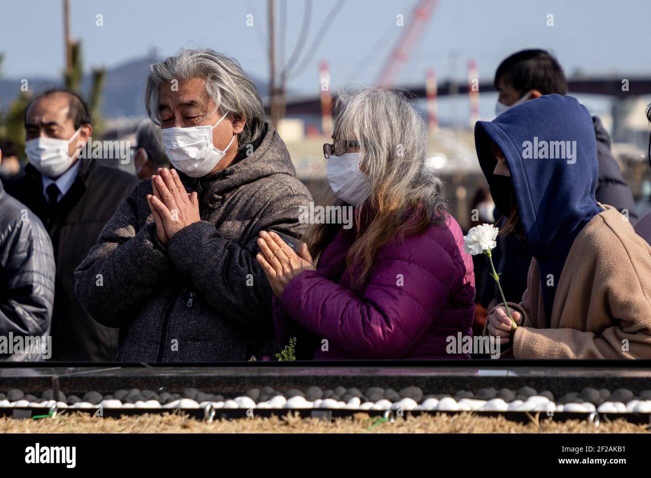 Ishinomaki, Giappone. 11 Marzo 2021. Una preghiera silenziosa è detta durante 14:46 il tempo del terremoto in 2011. Le famiglie e gli amici vengono a cercare nomi e offrono fiori e pagatori in ricordo dei cari nel nuovo parco commemorativo inaugurato oggi a Ishinomaki. Il Giappone segna 10 anni da quando un terremoto, uno tsunami e una crisi nucleare hanno colpito duramente il Giappone nordorientale. Credit: SOPA Images Limited/Alamy Live News Foto Stock