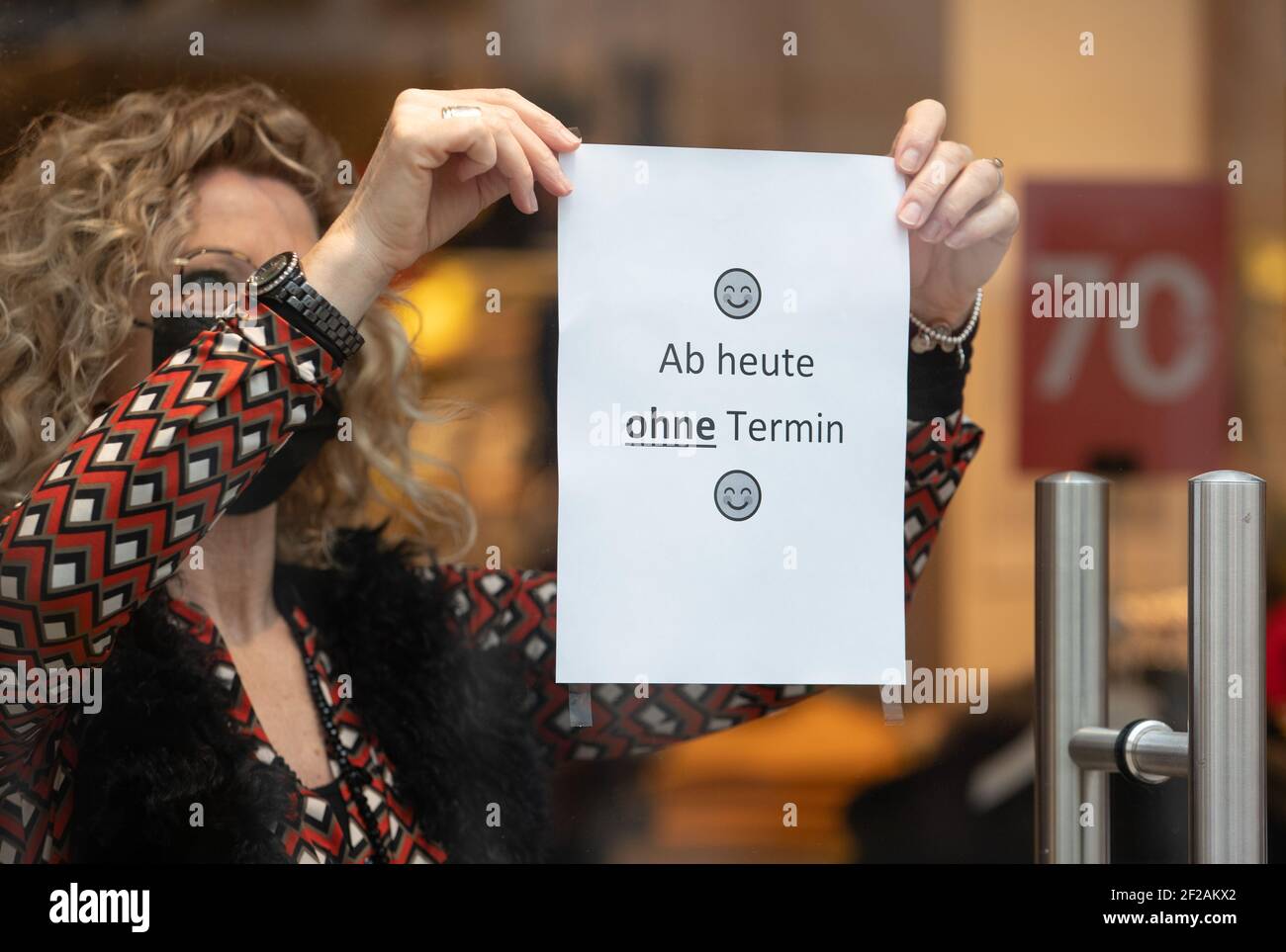 Bielefeld, Germania. 11 Marzo 2021. Un venditore appende una nota sulla porta del suo negozio dicendo 'da oggi senza appuntamento'. Diversi comuni della NRW con bassi numeri di corona stanno approfittando dell'opportunità di relax locale nel commercio e nella cultura e di offrire viaggi di shopping senza un appuntamento. Credit: Friso Gentsch/dpa/Alamy Live News Foto Stock