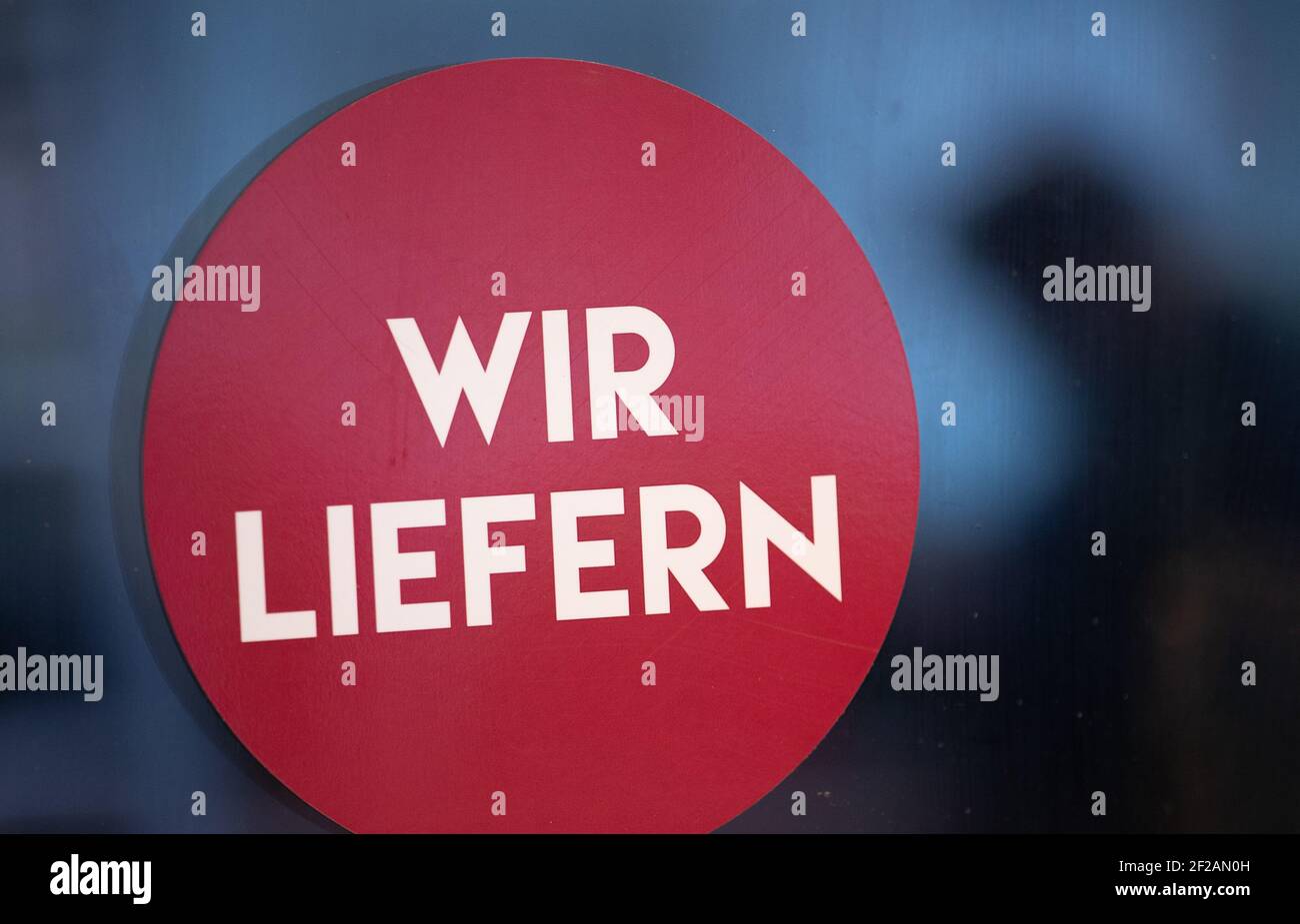 Bielefeld, Germania. 11 Marzo 2021. "Noi consegniamo" è scritto sul vetro di una porta di un negozio. Diversi comuni della NRW con bassi numeri di Corona stanno approfittando dell'allentamento locale del commercio e della cultura e offrendo i viaggi di shopping senza registrazione. Credit: Friso Gentsch/dpa/Alamy Live News Foto Stock