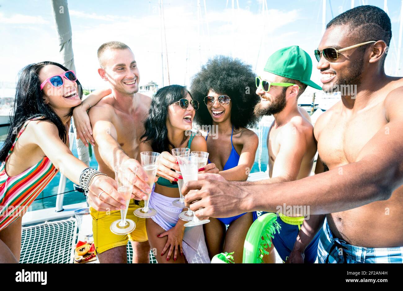 Amici multirazziali che si divertono a bere champagne a bordo di una barca a vela Festa - concetto di amicizia con giovani multirazziali su barca a vela Foto Stock