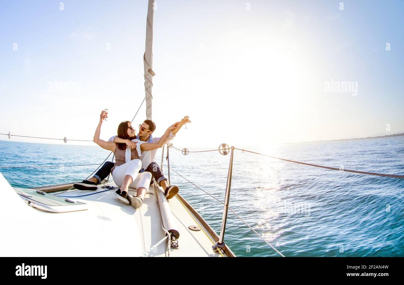 Giovane coppia innamorata a bordo di una barca a vela con champagne Tramonto - Happy People Lifestyle su concetto esclusivo di lusso - Messa a fuoco con retroilluminazione morbida Foto Stock
