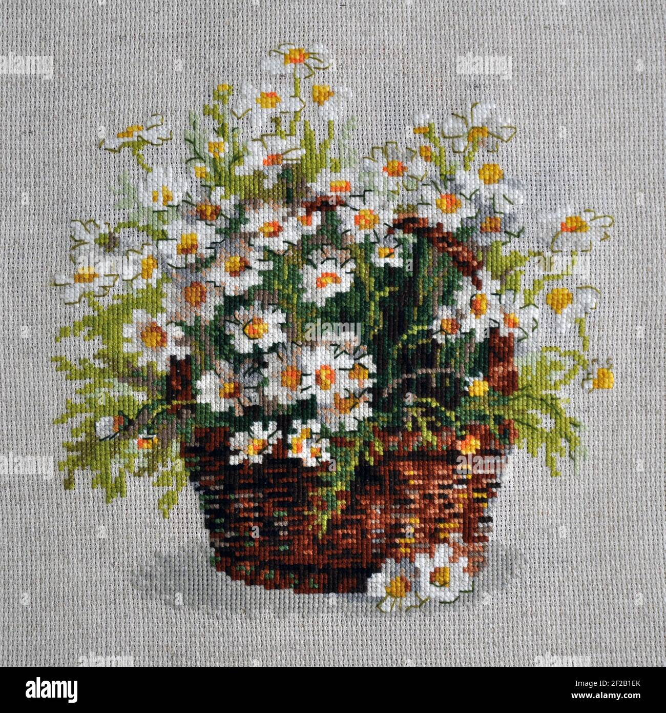 8 marzo 2021 - Mosca, Russia: Disegno ricamato di Riolis. Un cestino di fiori. Margherite russe. Foto Stock