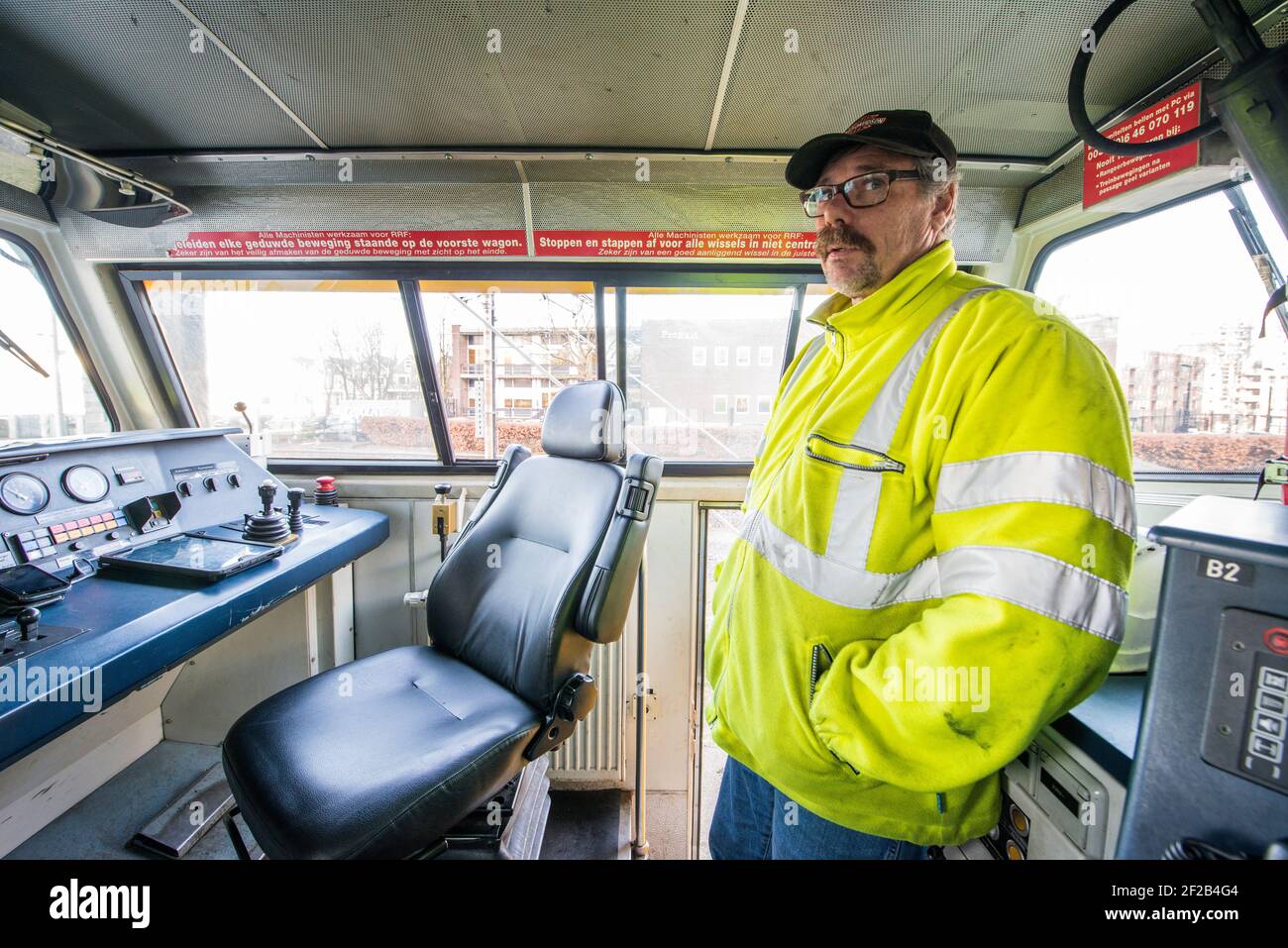 Rotterdam, Paesi Bassi. Conducente di un treno di supporto diesel, di sesso maschile e medio adulto, che sostiene un grande lavoro di revisione sui binari del treno da parte di un subappaltatore dell'organizzazione ProRail. Rotterdam, Zuid-Olanda. Trein machinist van een diesel goederentrein onderteund het groot onderhoud aan het spoor van de Willemboortunnel door een onderaannemer van ProRail. Foto Stock
