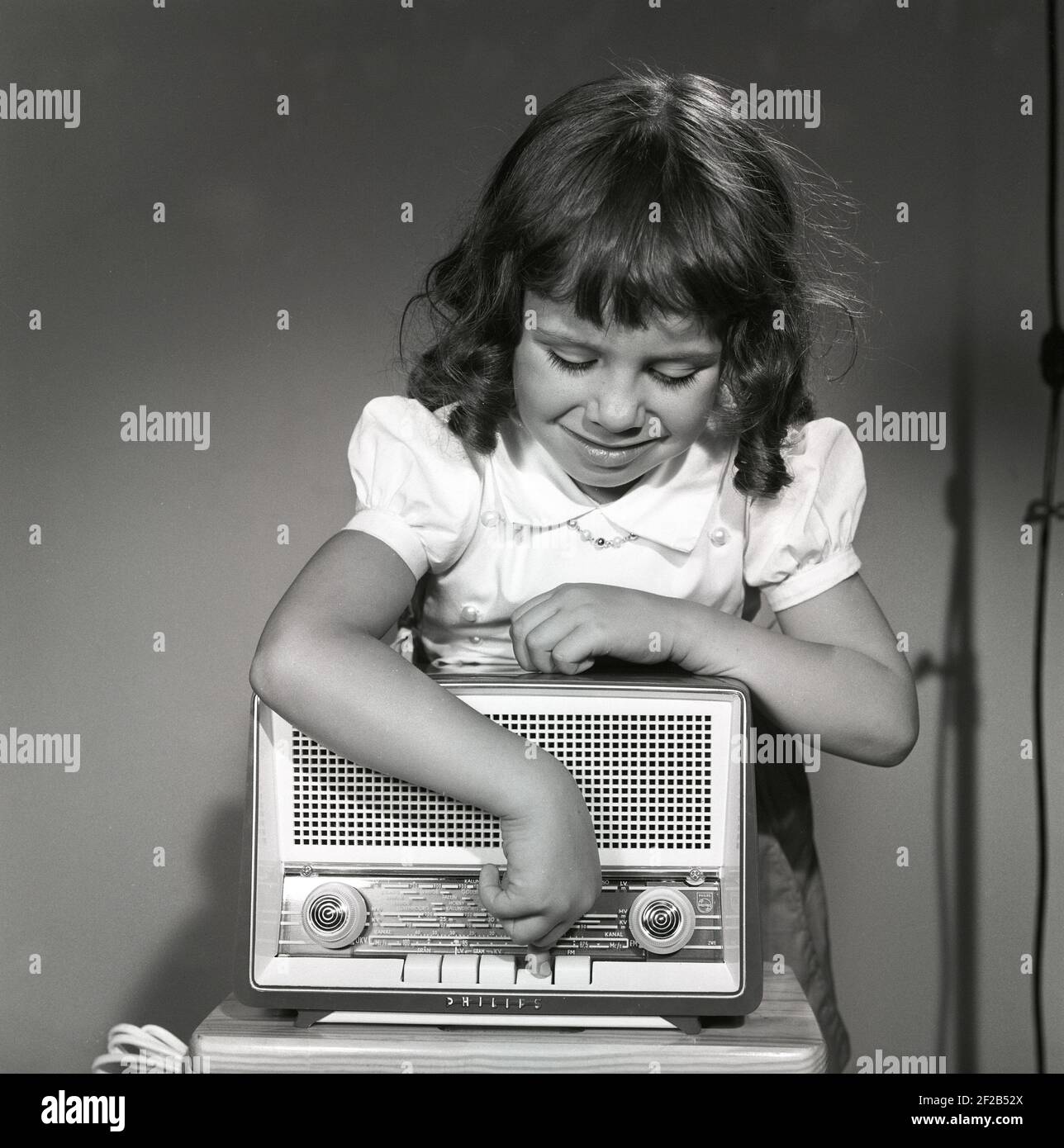 Negli anni '50. Una ragazza con un apparecchio radio Philips. Sulla parte  anteriore di esso una scala con informazioni di stazioni radio e frequenze  diverse. Svezia 1959. rif CG70-10 Foto stock - Alamy