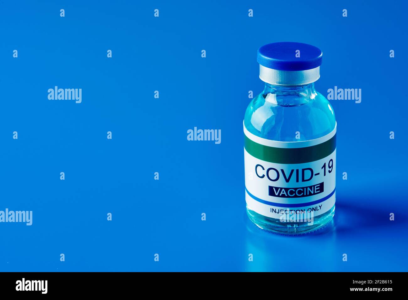 una fiala simulata di vaccino covid-19 su sfondo blu, con un po' di spazio vuoto sulla sinistra Foto Stock