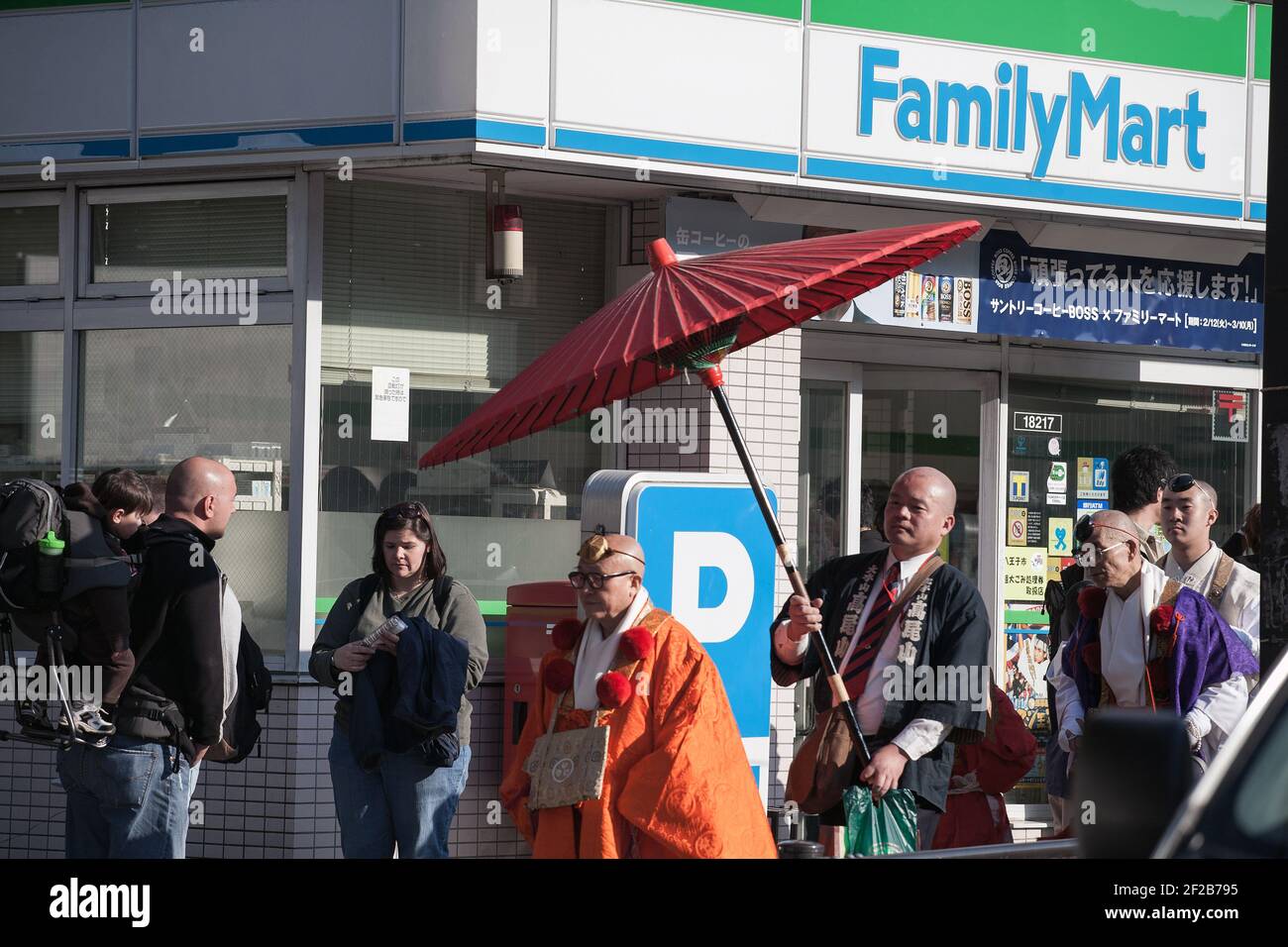 Il sacerdote cammina oltre il mart della famiglia partecipando al festival Hiwatari Matsuri - Fire Walking, il monte Takao, Hachioji, Giappone Foto Stock