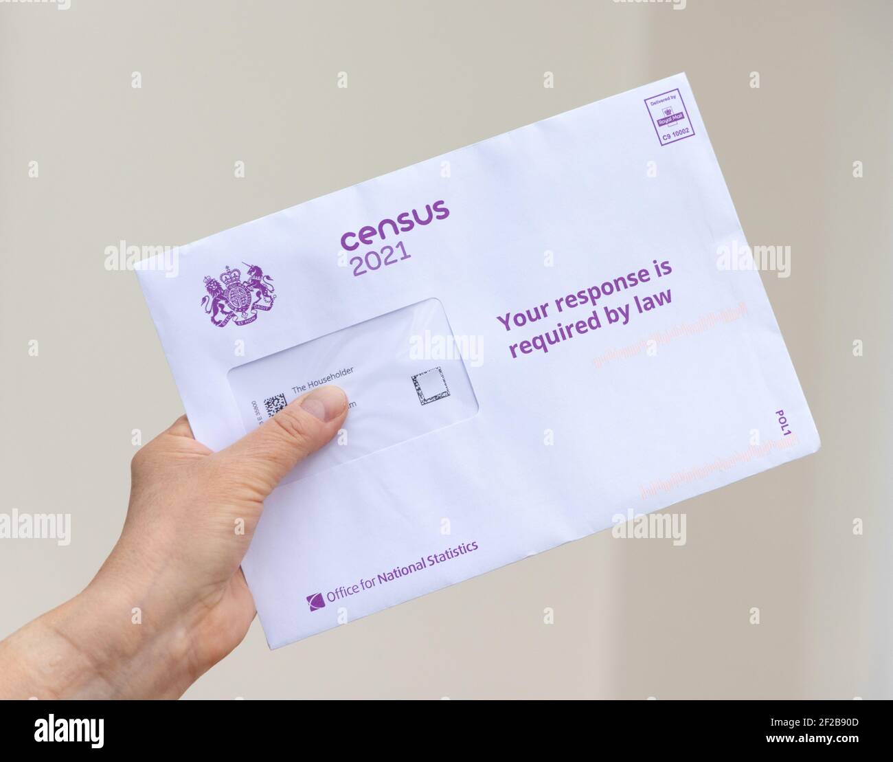 Tenere a mano una busta contenente un opuscolo e un codice di accesso per la famiglia per completare online il censimento del Regno Unito 2021. Foto Stock