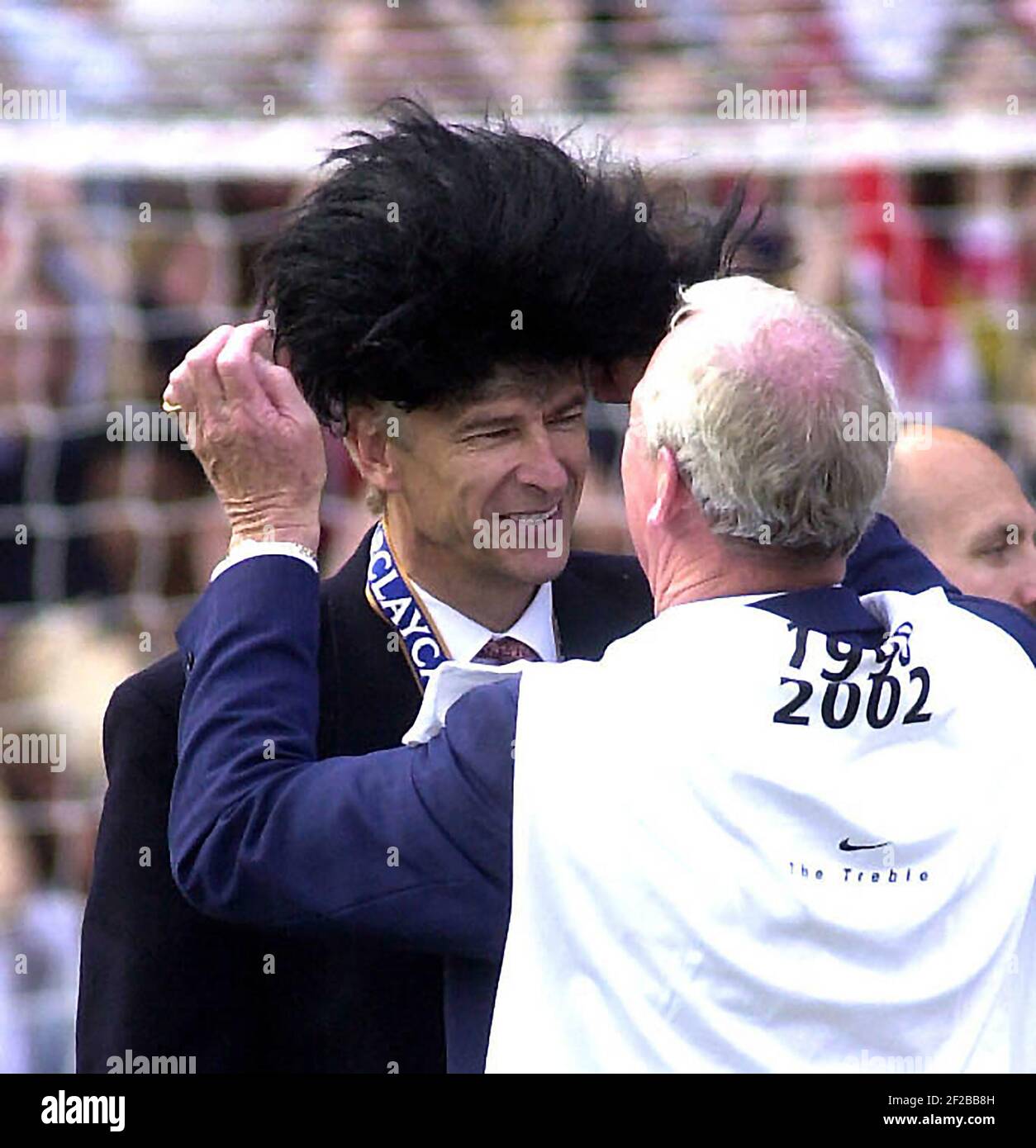 Arsenal V Everton 11/5/02 Bob Wilson mette Elvis Wig su Foto di Arsene Wenger di Gavin Rodgers 07957 177089 Foto Stock