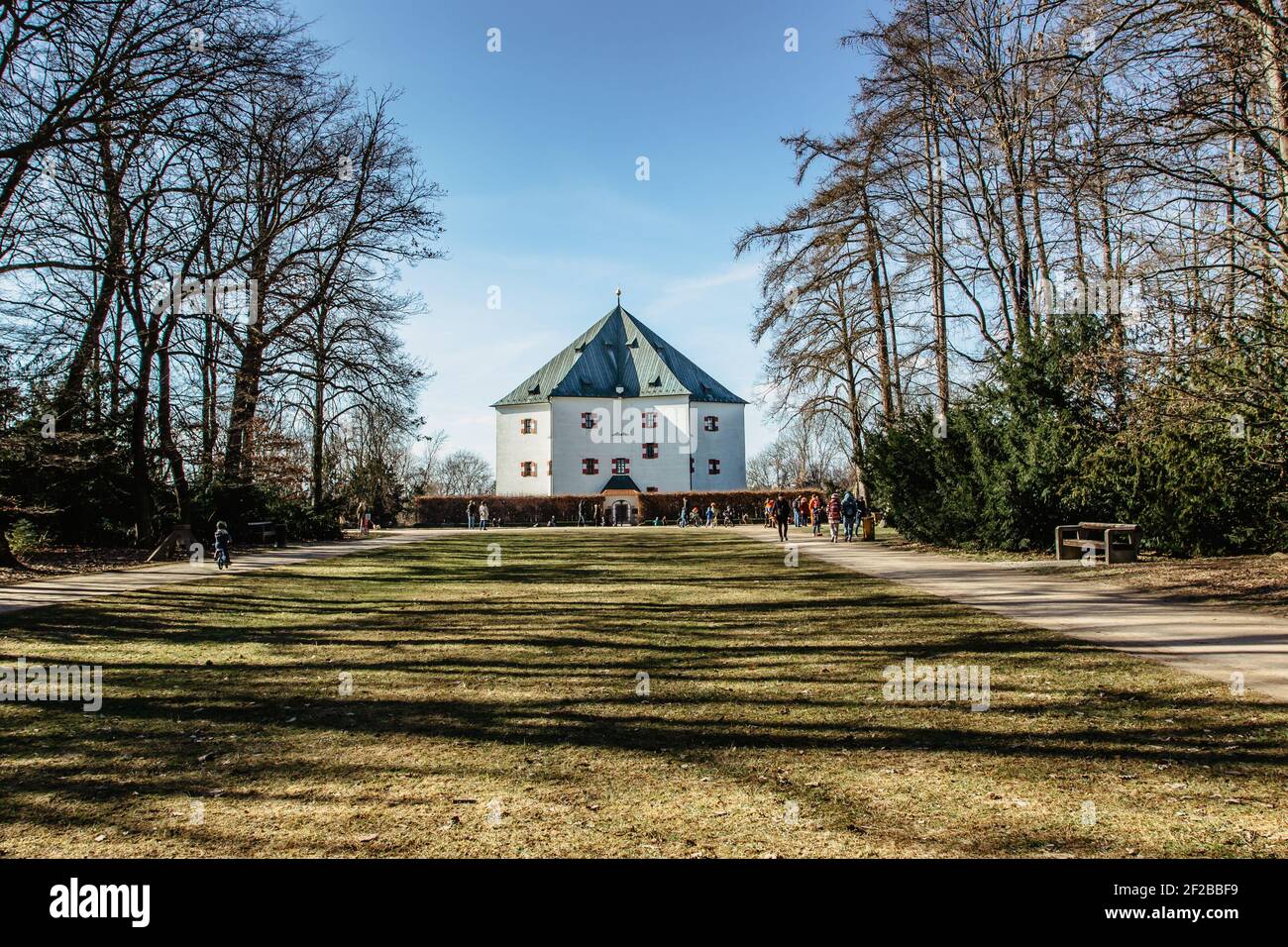 Praga, Repubblica Ceca - 6 marzo 2021. Palazzo Estivo di Hvezda e persone che camminano nel parco con maestosi viali alberati. Edificio rinascimentale in forma Foto Stock
