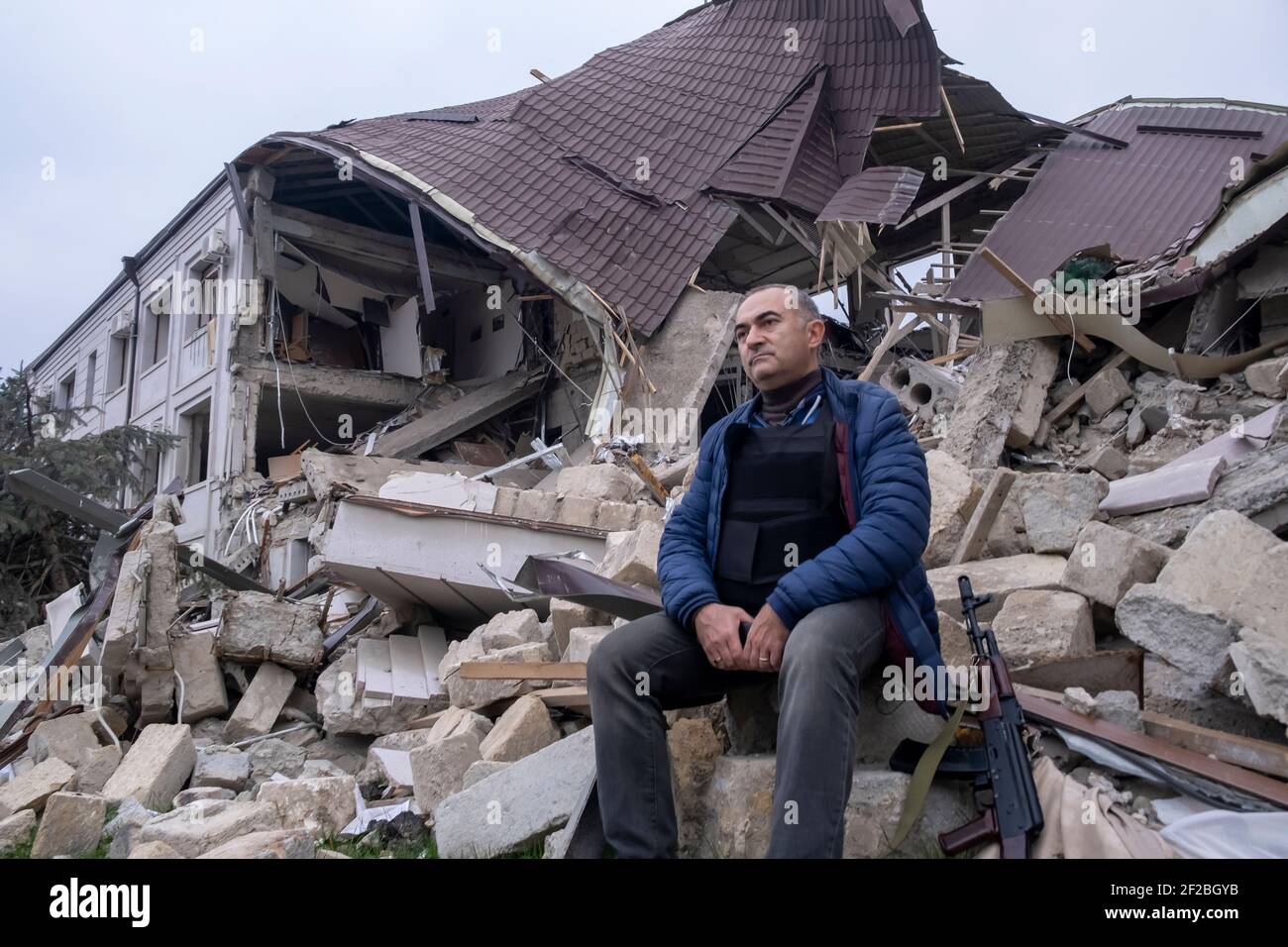 STEPANAKERT, NAGORNO KARABAKH - NOVEMBRE 04: Tevan Pogosyan consigliere del presidente armeno ed ex-membro del Parlamento armeno armato di un fucile AK-47 Kalashnikov siede nel relitto del principale edificio di controllo elettrico di Artsakh Energo distrutto da un attacco militare azero durante un conflitto militare a Stepanakert, capitale de facto dell'autoproclamata Repubblica di Artsakh o Nagorno-Karabakh, parte de jure della Repubblica di Azerbaigian il 04 novembre 2020. I combattimenti tra Armenia e Azerbaigian sul Nagorno-Karabakh conosciuto anche come la Repubblica Artsakh rieruttarono alla fine di settembre Foto Stock